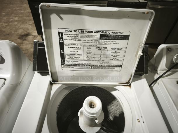 Whirlpool LA5580XTW1 washer, top view with open lid displaying control instructions, in used condition.