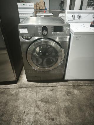 Samsung 27" front-load steam washer, model WF448AAP, stainless finish, with control panel, visibly used condition.