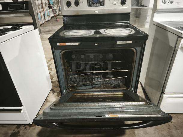 Whirlpool 30" electric range model RF362LXSS, self-cleaning, freestanding, open oven door, visible wear, warning label shown.