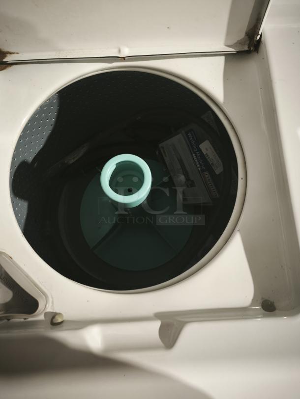 Maytag A511 top-load washer interior view, showing agitator and inner tub. Visible rust on lid hinge, otherwise good condition.
