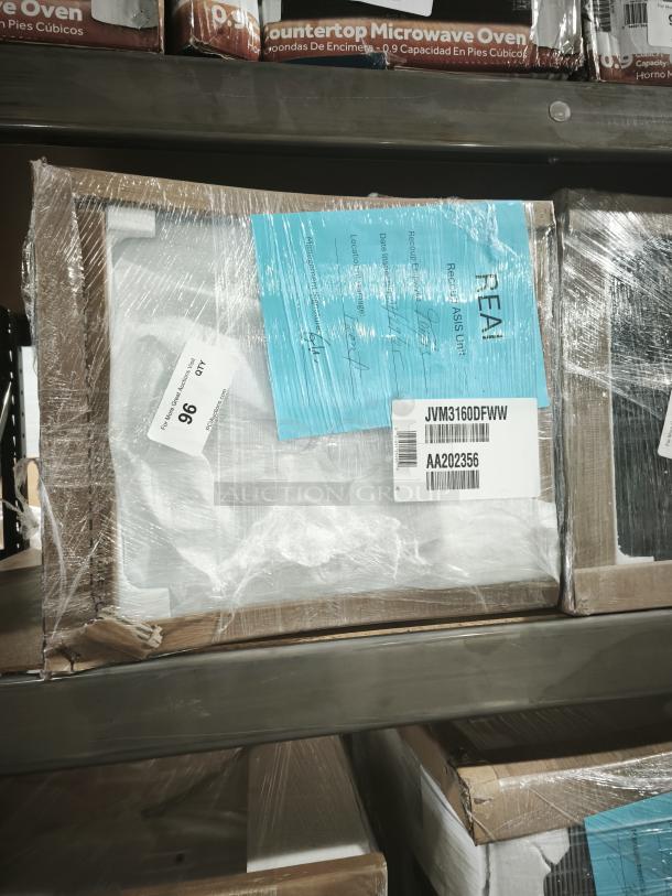 GE 1.6 Cu. Ft. over-the-range microwave, white, model JVM3160DFWW, new in box with visible packaging labels.