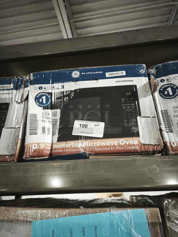 BRAND NEW GE 0.9 Cu. Ft. Countertop Microwave, Model GCST09N1WBB, Black. Scratches and dents are present. Box label shows specs.