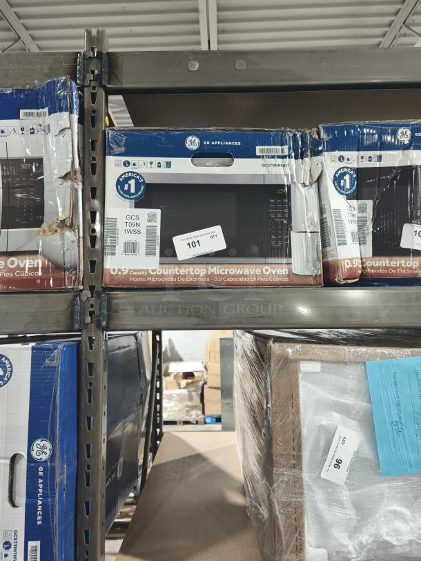GE® 0.9 Cu. Ft. Countertop Microwave Oven, model GCST09N1WSS, boxed on shelf, slight packaging wear.
