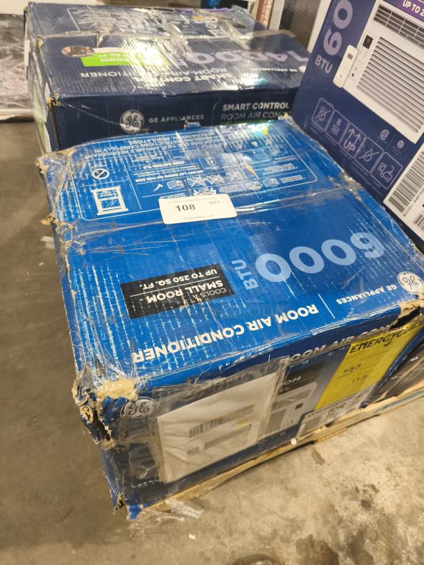 GE 6,000-BTU window air conditioner, model AHQ06LYC. Box shows wear with torn edges. Energy guide label visible.