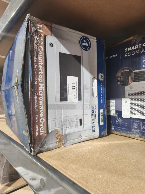 Brand new GE 1.1 Cu. Ft. white countertop microwave, model GCST11N1WWW, in original box with scratches and dents.