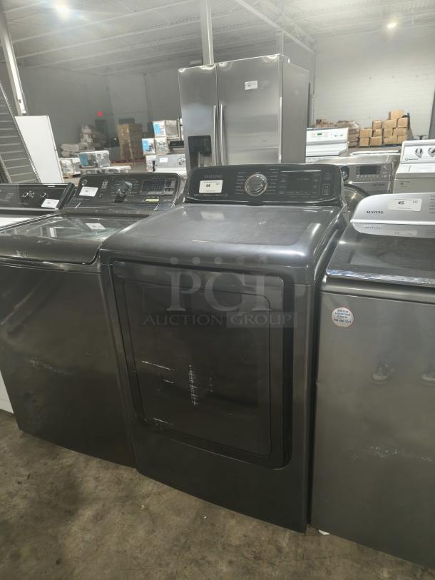 SAMSUNG 7.4 Cu. Ft. black stainless electric dryer with steam, model DVE52M7750V/A3, visible control panel and minor surface marks.