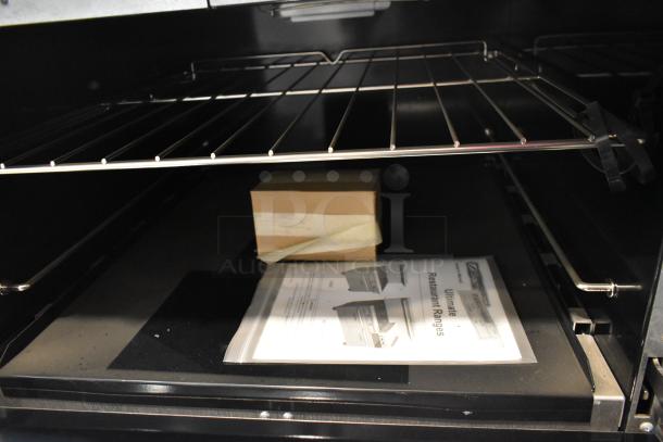 Brand new Southbend 4601DD stainless steel commercial range interior, showcasing oven racks and included manual.