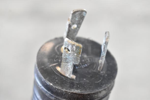 Close-up of a three-prong plug for a Turbochef ECO electric rapid cook oven, showing metal prongs and a black base.