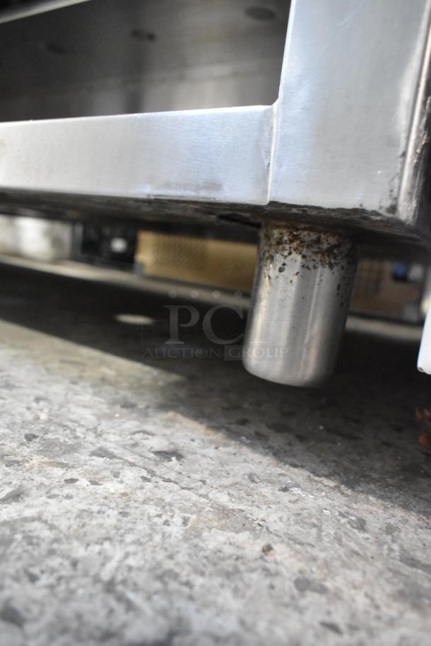 Stainless steel steam table base with visible rust on a leg, indicating aged condition.