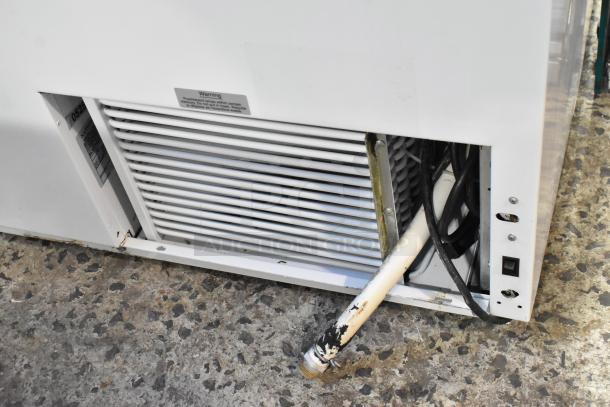 Kelvinator metal commercial ice cream dipping cabinet, white exterior, visible venting and wiring, label indicates model.