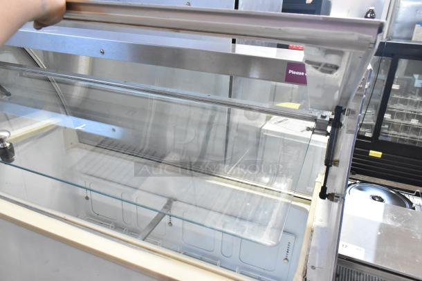 Kelvinator metal commercial ice cream dipping cabinet in used condition, features a sliding glass top and metal frame.