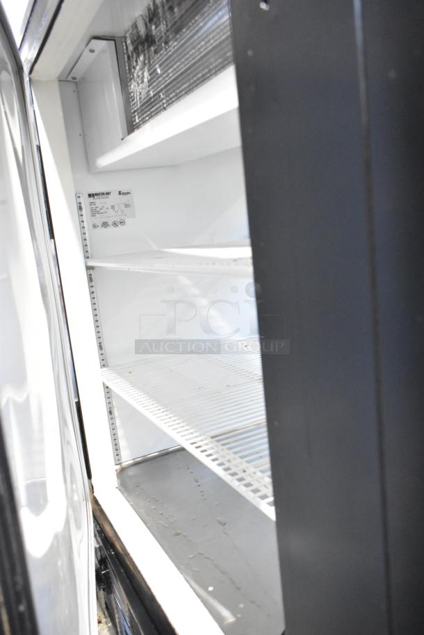 Master Bilt FTP-40 metal commercial deli display case, glass front, shelves visible, model and voltage label inside.