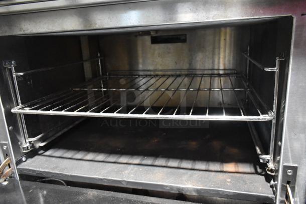 Sierra stainless steel commercial gas range with 6 burners, oven, over shelf, and backsplash. Interior view of oven.