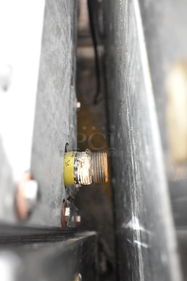 Close-up view of the Sierra gas connection, featuring a threaded metal fitting, on a 6-burner range and oven.