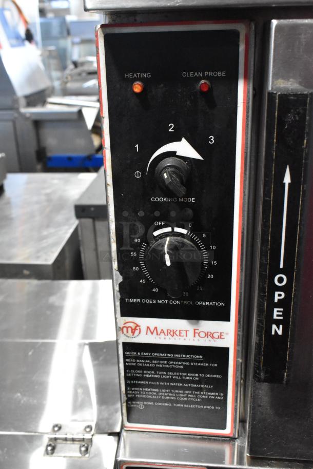 Market Forge stainless steel commercial steam cabinet control panel with dials for cooking mode and timer, featuring operational instructions and branding.