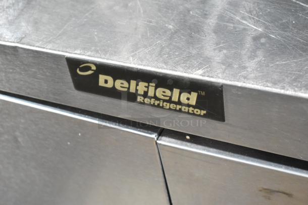 Delfield stainless steel prep table, mega top, 4 drawers, over shelf. Visible Delfield label, 115V, 1 phase.