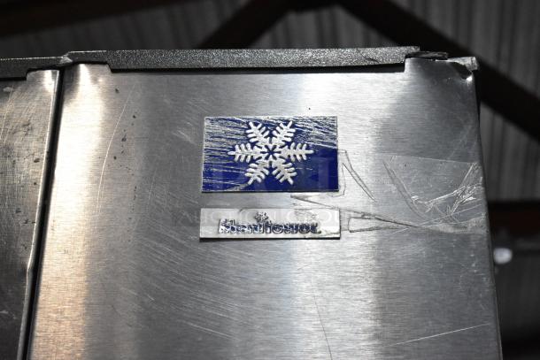 Manitowoc SY0854A stainless steel commercial ice head on bin, visible wear, blue snowflake logo, 208-230V, 1 phase.