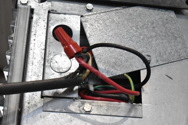 Manitowoc SY0854A stainless steel commercial ice head, visible wiring, 208-230V, 1 phase, on commercial ice bin.