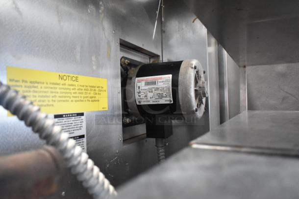 Bakers Pride BCO11G convection oven fan motor with warning labels. Stainless steel interior detail visible.