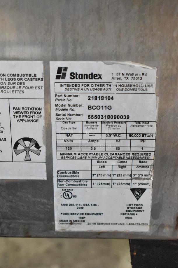 Bakers Pride BCO11G convection oven label, showing gas type, model: BCO11G, 60,000 BTU, clearances, and Standex branding.
