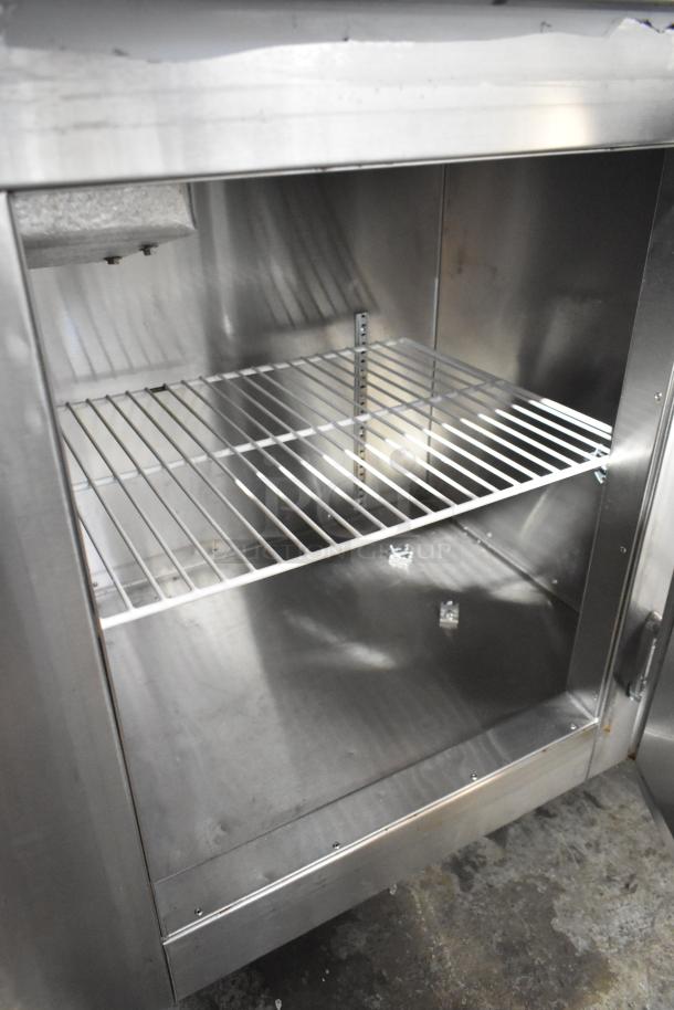 Stainless steel 2-door undercounter cooler with commercial casters, 115V, 1-phase. Clean interior and adjustable shelf visible.
