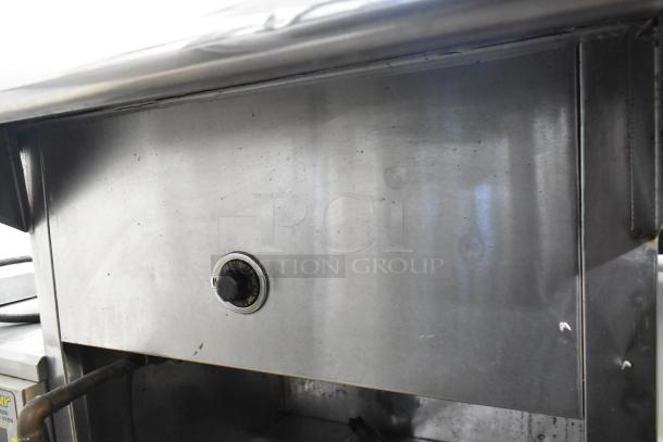Stainless steel commercial electric steam table with sneeze guard, featuring control knob. Appears in used condition.