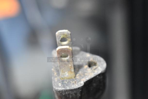 Close-up of a worn, two-prong electrical plug for an Eurodib USF-54S Metal Mini Wine Chiller, 115 volts, 1 phase.