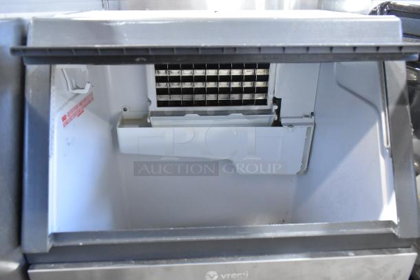 2023 Vremi stainless steel undercounter ice machine, commercial-grade, 115V, 1 phase, self-contained, shown open with ice grid.