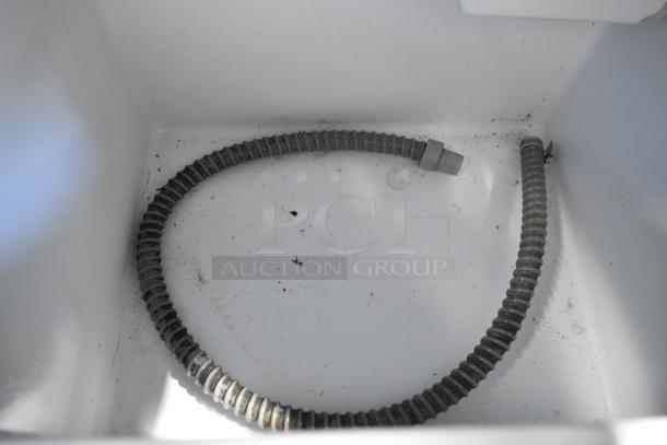 2023 Vremi Stainless Steel Ice Machine interior showing drain hose. Signs of use visible, needing cleaning.