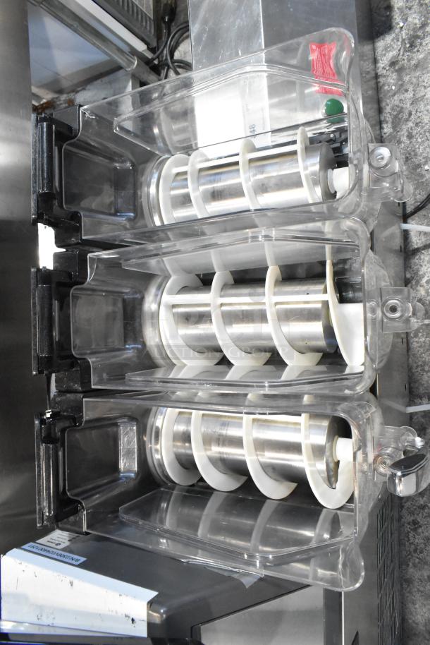 Metal commercial countertop slushie machine with 3 hoppers. Operates at 115 volts, 1 phase. Clear plastic lids visible.