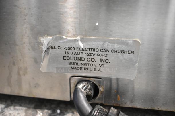 Edlund CH-5000 stainless steel commercial can crusher. Label shows model, voltage, and manufacturing details.