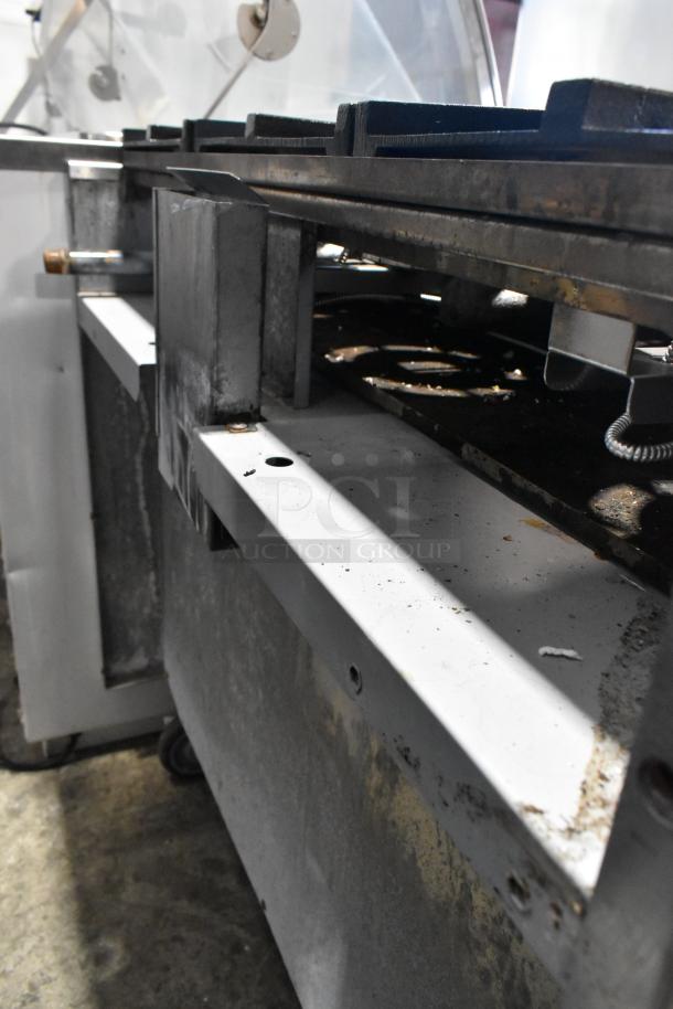 Sierra stainless steel 6-burner gas range with oven on commercial casters, showing sturdy construction and moderate wear.
