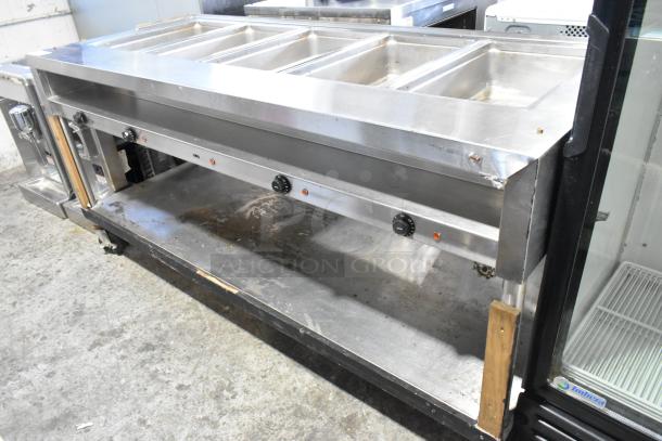 Stainless steel commercial 4 bay steam table with under shelf, on commercial casters. Features temperature knobs and stainless finish.