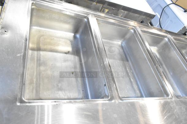 Stainless steel 4 bay steam table with under shelf. Commercial casters, slightly used condition, ideal for catering.