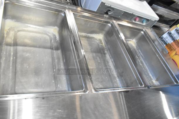 Stainless steel 4 bay steam table with under shelf on commercial casters, showing lightly used condition.