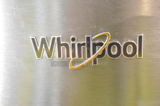 Whirlpool logo on 2024 WRT311FZDM15 stainless steel cooler with freezer, showing brushed metal finish and brand emblem.
