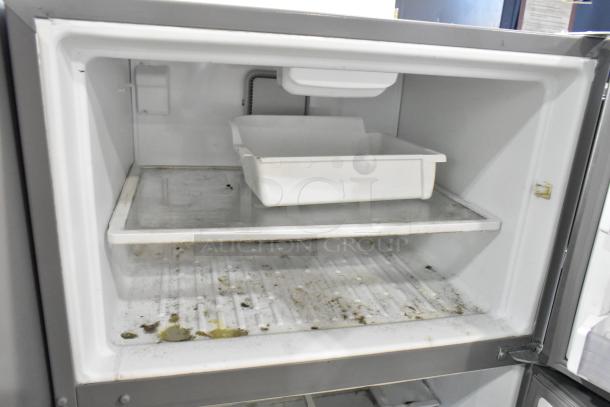 Whirlpool stainless steel cooler with freezer, 115 volts, 1 phase. Visible interior wear and marks. Includes removable tray.