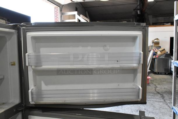 Whirlpool stainless steel cooler with freezer, 115 volts, 1 phase. Features interior door shelves. Used condition.