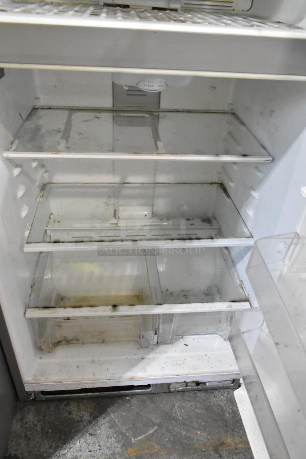 Whirlpool stainless steel cooler with freezer, showing interior with multiple shelves, visible wear and some stains. 115 volts, 1 phase.