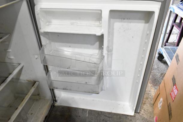 Whirlpool stainless steel cooler with freezer, 115 volts, 1 phase. Visible interior shelves, slight wear, clean exterior.