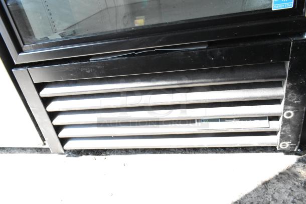 True GDM-26-HC cooler vent detail, showing black metal frame with horizontal slats and Energy Star label, 115V, 1-phase.