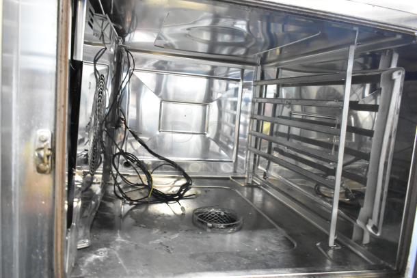 Stainless steel interior of Rational iCombiPro convection oven, model LM100CE.AXXXX/LM100EE.AXXXX, showing racks and wiring.