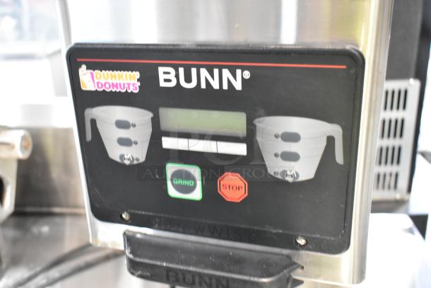 Bunn MHG stainless steel commercial 2-hopper coffee bean grinder, 120V, features grind and stop buttons, Dunkin' Donuts branding.