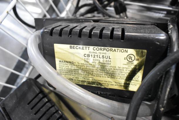 Beckett CB121LSUL pump label, 115V, 60Hz, 0.48A. UL Listed, thermally protected. Black casing with visible tubing.