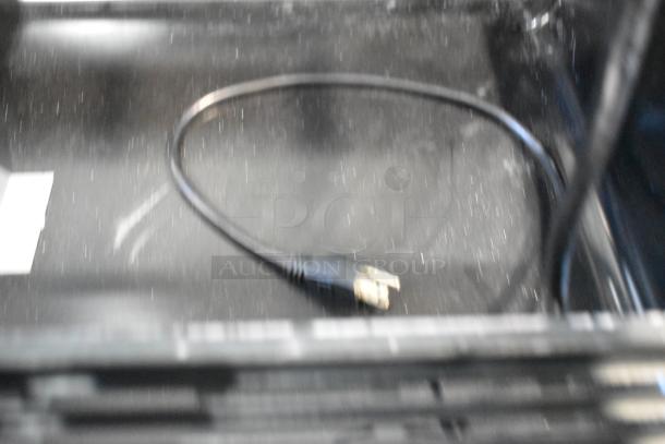 Blurred image of an Avantco 193BCD48B curved glass bakery display case interior with visible power cord.