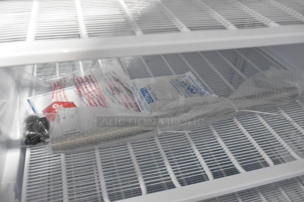 Brand new KoolMore KM-FMD20WH commercial freezer interior; visible poly-coated racks, packaging materials included.