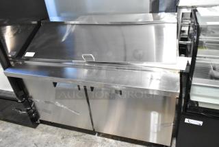 Brand new Avantco 178APT60MHC stainless steel 2-door refrigerated sandwich prep table with commercial casters and slight dents.