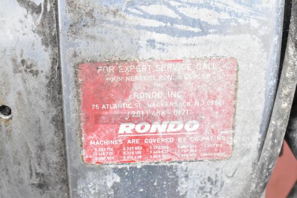 Rondo Seewer metal commercial dough sheeter, unassembled, possibly missing parts, worn condition, red label with contact details.