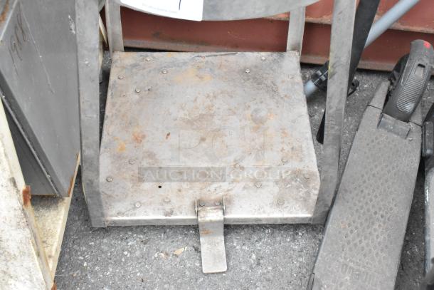 Metal mixing bowl stand with under shelf, slightly rusted, sturdy construction, ideal for kitchen use or storage.