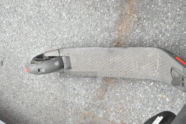 Ninebot scooter deck, black with anti-slip surface, visible wear, Ninebot logo embossed.